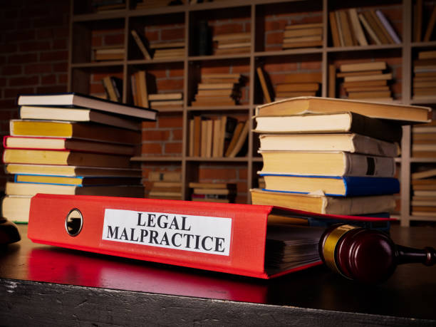 stack of books with one that says legal malpractice